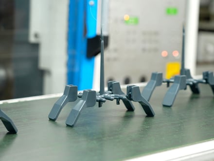 多数個取り金型から突き出された直後の AMP 精密成形品。ランナーシステムに付いたままで、ゲートカット待ちの状態。