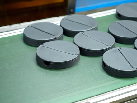 生産コンベア上に並ぶ AMP の精密成形部品。表面仕上がりが安定しており、検査と梱包を待つ状態。